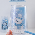 Globe de Noël DIY décoré avec des flocons de neige et un sapin miniature.