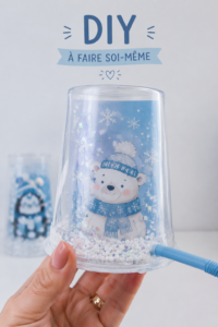 Globe de Noël DIY décoré avec des flocons de neige et un sapin miniature.