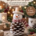 Un bonhomme de neige en pommes de pin décoré, assis sur une table avec des éléments naturels autour.