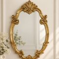 Un grand miroir baroque avec un cadre doré élégant, posé sur un mur de salon.
